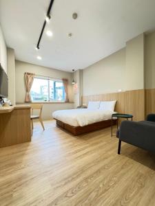 台南市にあるYoshi Hotel Xinmei Streetのベッド、テレビ、ソファのある寝室