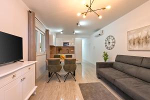 een woonkamer met een bank en een flatscreen-tv bij Apartment Amarilis in Mandre