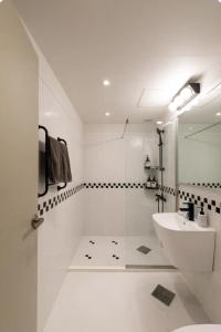 a white bathroom with a sink and a mirror at Hongdae St10, wide,bright & stylish house in Seoul