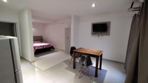 Habitación con mesa, cama y TV. en Loft San Lorenzo, en Bahía Blanca 5 fotos más