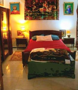 a bedroom with a bed with a red comforter at Villa Dar El Bey in Tozeur