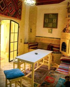 a living room with a table and a fireplace at Villa Dar El Bey in Tozeur