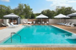 a large swimming pool with chairs and umbrellas at Villa Pasis 2 in Rovinj