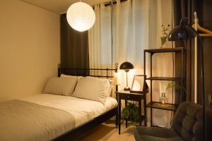 een slaapkamer met een bed, een plank en een lamp bij Seoul wannabe stay, Gangnam 20 mins, Hongdae 20mins in Seoul