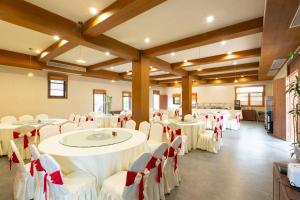 a banquet hall with white tables and red chairs at Chaoyangli Folk Resort Hotel in Zhaoqing +110 photos