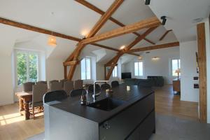 a kitchen with a black island in a living room at Appartement T5 145m2 4 chambres, vue lac climatisé in Tresserves