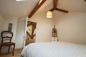 a bedroom with a white bed and a chair at Appartement T5 145m2 4 chambres, vue lac climatisé in Tresserves +40 photos