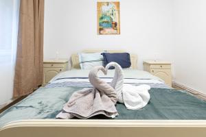 a bedroom with swans towels on a bed at Apartament Cetate in Alba Iulia
