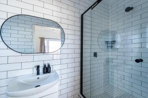 a white bathroom with a sink and a mirror at The White House - Kleinkrantz in Wilderness