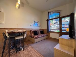 a living room with a couch and a table at Résidence Britania Clés Blanches in La Tania