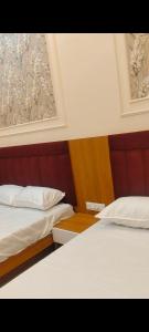 two beds sitting next to each other in a bedroom at Hotel Shree Shyam Palace in Ujjain