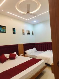 a bedroom with two beds and a ceiling at Hotel Shree Shyam Palace in Ujjain