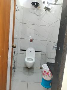 a white bathroom with a toilet and a sink at Hotel Shree Shyam Palace in Ujjain