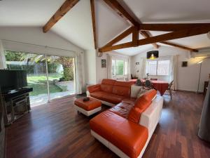 a living room with a couch and a tv at Belle villa calme, parking, jardin, Climatisation in Biarritz