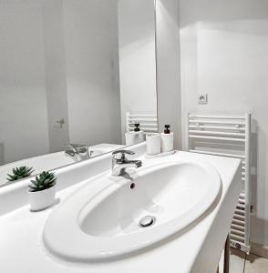 een witte badkamer met een wastafel en een spiegel bij Sweet Dream Chessy-Near Disney, Parking privée in Chessy