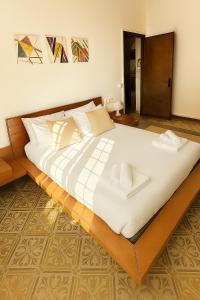 a large bed with white sheets and pillows at Casa Emma 15 Minuti dal Centro di Roma in La Massimina-Casal Lumbroso