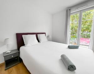 een slaapkamer met een groot wit bed en een raam bij Sweet Dream Chessy-Near Disney, Parking privée in Chessy