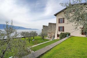 MusloneにあるVilla Victoria Lake frontの水辺の芝生の庭がある大きな建物