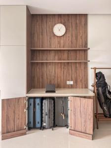 a desk with a clock on a wall with luggage at Hygge Haven Saigon in Ho Chi Minh City +26 photos
