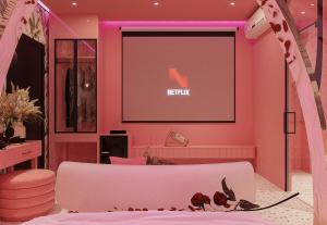 a room with a pink wall with a large screen at inluv hotel in Long Xuyên