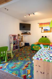 a room with a bed and a play room with a rug at Osada Na Ochodzitej in Koniaków