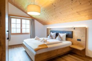 a bedroom with a large bed and a wooden ceiling at Landal Brandnertal in Bürserberg