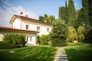a large white house with a grass yard at Villa Aria in San Felice del Benaco