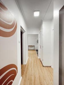 an empty hallway with white walls and wood floors at Gem 1 - Gladstone Suva CDB 2Bedroom Apartment in Suva