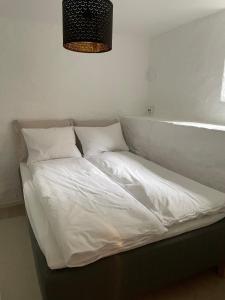 een bed met witte lakens en kussens in een kamer bij Tranquility near everything - Majorstua in Oslo +3 foto's