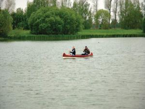 two people in a red boat on a lake at 4 star holiday home in Ottendorf in Otterndorf