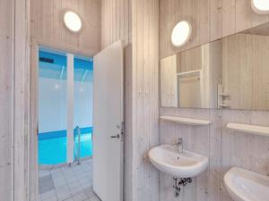 a white bathroom with a sink and a mirror at 4 star holiday home in Ottendorf in Otterndorf +92 photos