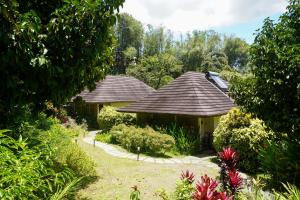 two houses in a garden with bushes and trees at Hidden Gardens Resort, Davao in Davao City