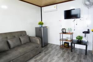 a living room with a couch and a tv at ไร่ผางาม ภูทับเบิก in Ban Maeo Thap Boek