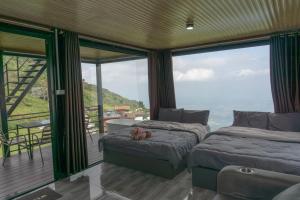 two beds in a room with a view of the ocean at ไร่ผางาม ภูทับเบิก in Ban Maeo Thap Boek +10 photos