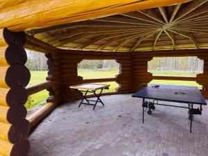 a patio with a ping pong table in a log cabin at Saules sēta in Lazdenieki