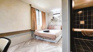 a small room with a bed and a shower at 艾睏設計行旅 Sleepie Design Hotel in T'ien-liao