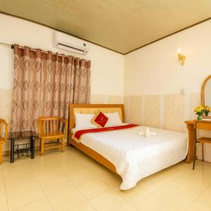 a bedroom with a large bed and a desk at Tân Tuấn Tuấn Hotel in Ho Chi Minh City
