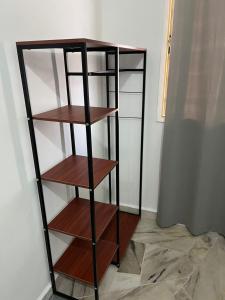 a book shelf with wooden shelves in a room at Mus Lim Homestay Aqil Bandar Puncak Alam in Bandar Puncak Alam