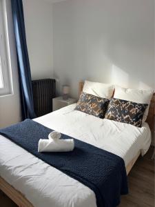 a bed with a blue blanket and a towel on it at La Terasse de Tours in Tours