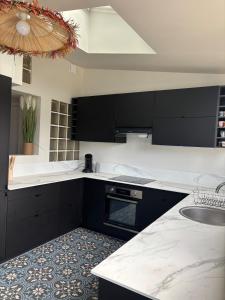 a kitchen with black cabinets and a white counter top at La Terasse de Tours in Tours