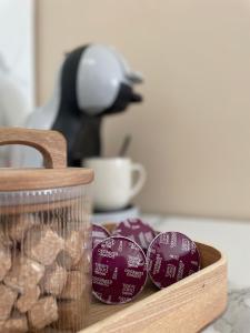 Una tabla de cortar de madera con galletas moradas y una taza de café. en Luminosa T2 lumineux proche Airbus parking, en Tournefeuille
