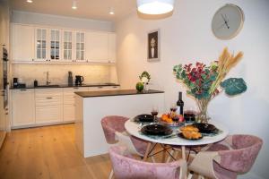 a kitchen with a table and chairs and a clock on the wall at Maya's Flats & Resorts - Staromiejski Apartments in Gdańsk +8 photos