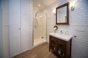 a white bathroom with a sink and a shower at Maya's Flats & Resorts - Staromiejski Apartments in Gdańsk