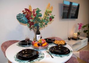 a table with two plates of food and a vase with flowers at Maya's Flats & Resorts - Staromiejski Apartments in Gdańsk