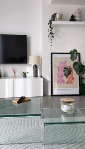 sala de estar con mesa de cristal y TV en Luminosa T2 lumineux proche Airbus parking, en Tournefeuille