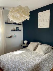 Un dormitorio con una cama con una pared azul. en Luminosa T2 lumineux proche Airbus parking, en Tournefeuille