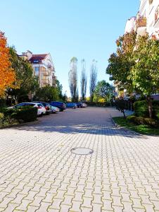 a cobblestone street with a parking lot with cars at Kolory Warmii Apartament Niebieski in Olsztyn