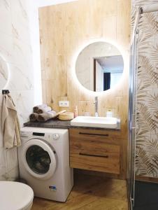 a bathroom with a washing machine and a sink at Kolory Warmii Apartament Niebieski in Olsztyn +10 photos