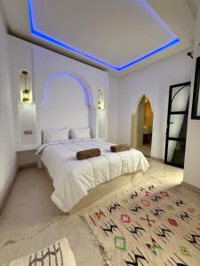 une chambre avec un grand lit avec un plafond bleu dans l'établissement Riad La Rose, à Marrakech