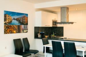 a kitchen with a table and chairs and a painting on the wall at 204 Paris 59m2 4-8 Pers extr Bedroom in Klagenfurt